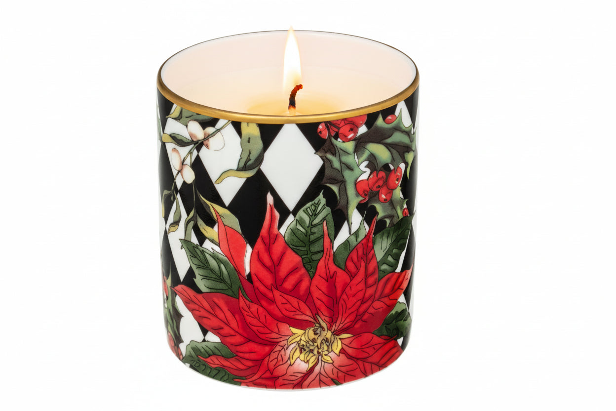 A black candle with a red poinsettia and holly design, featuring a gold rim at the top.